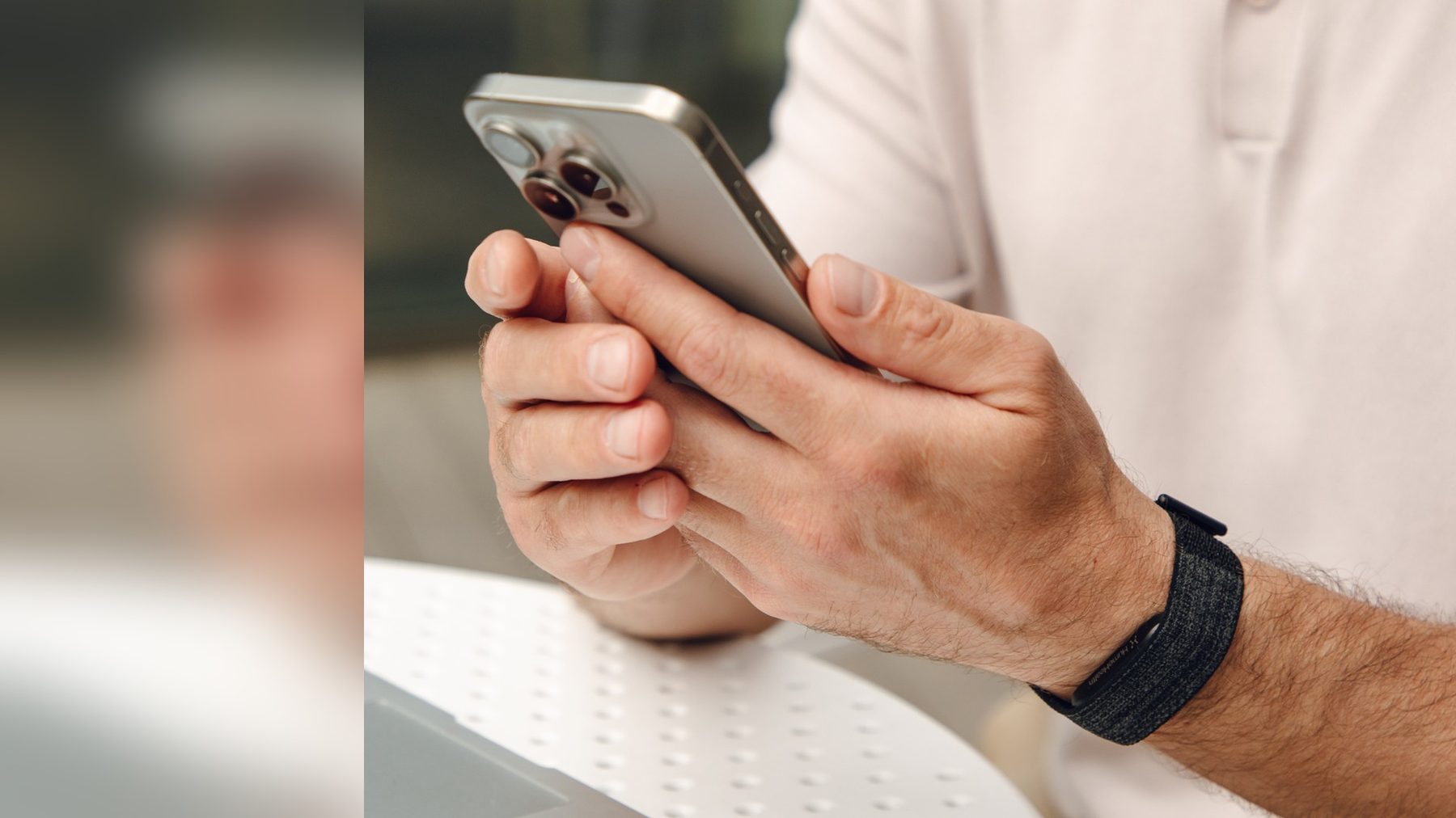 Close-up of a member wearing the Hume Band 2.0 while holding a phone